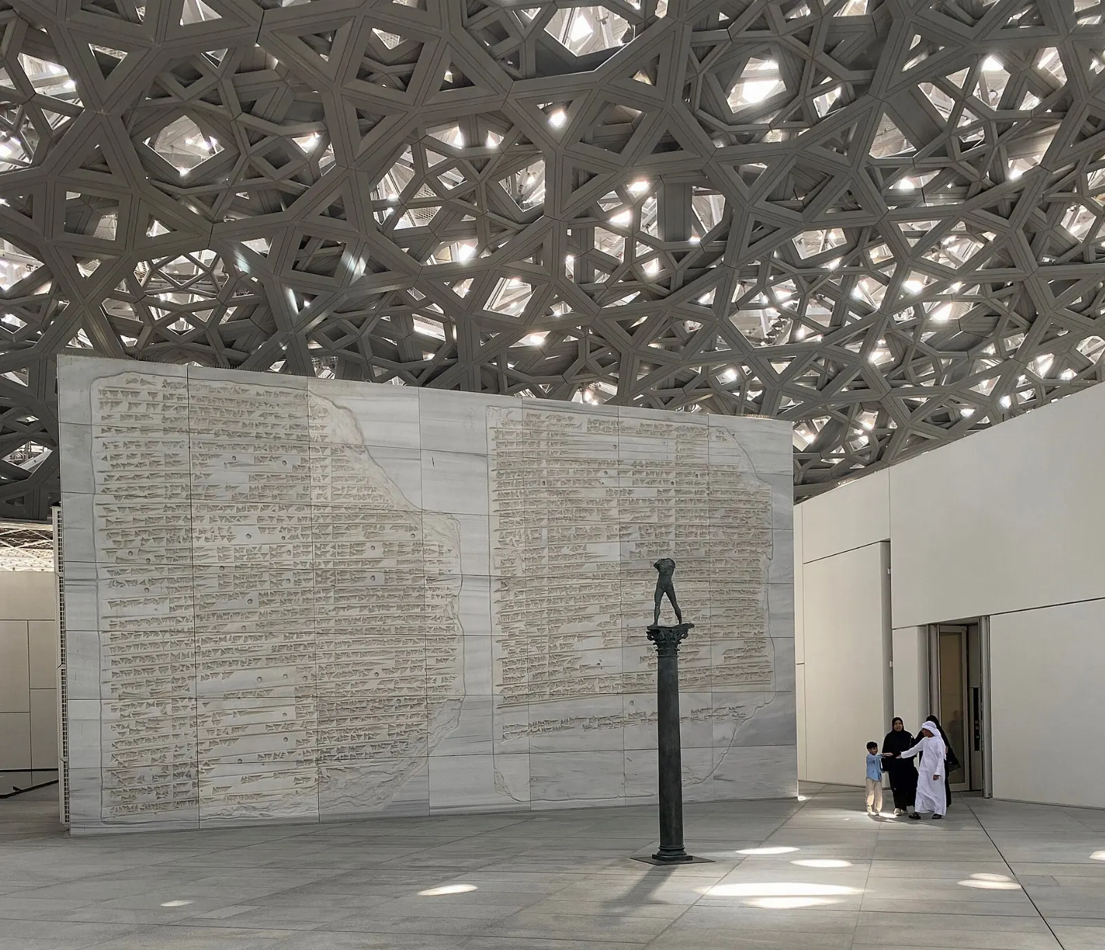 Patterned latticed dome of the Louvre Abu Dhabi over the water at dusk, United Arab Emirates