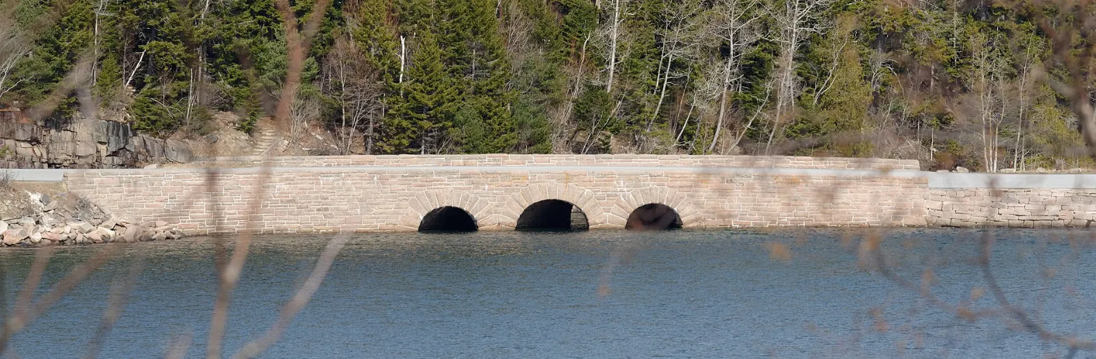 Arched granite bridge over a stream on one of Acadia's broken-stone carriage roads, Acadia National Park, Maine
