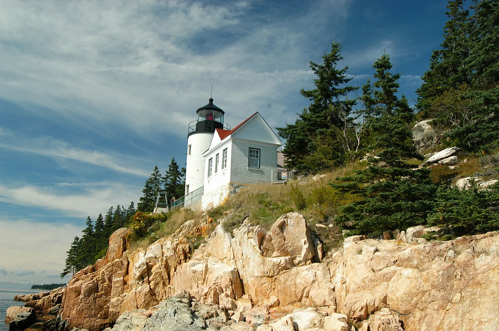White lighthouse on a rocky ledge above the sea at Bass Harbor Head, Acadia National Park, Maine