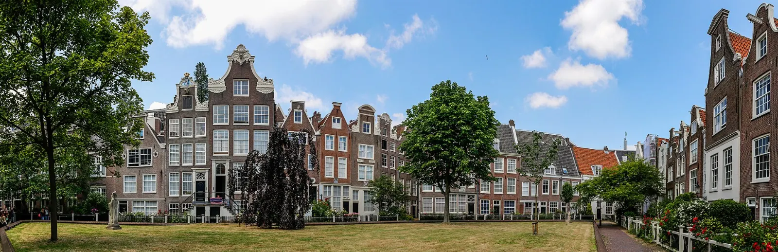 Historic houses around a quiet green courtyard in the Begijnhof, Amsterdam, Netherlands