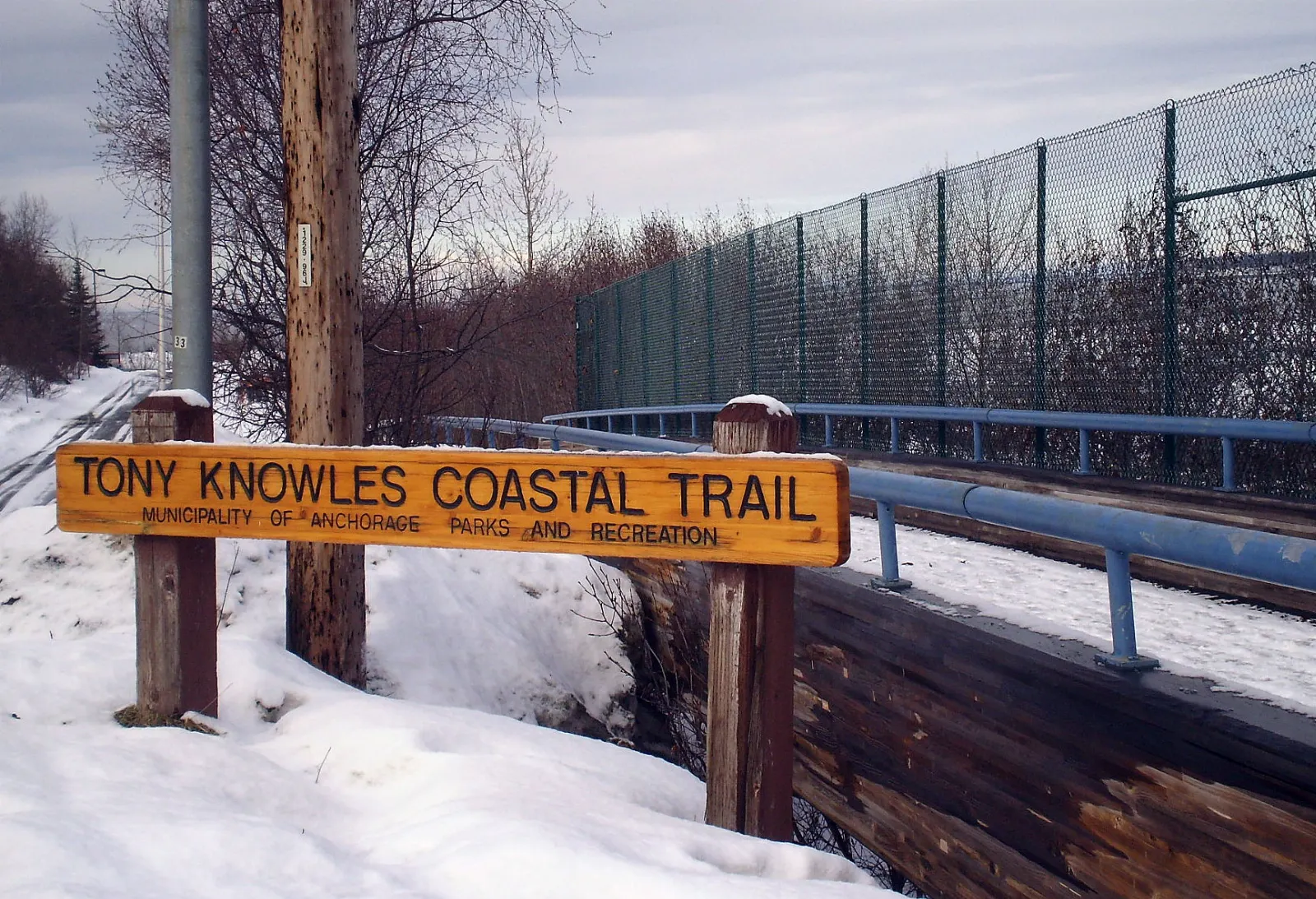 A paved trail curving along the mudflats of Cook Inlet with downtown Anchorage in the distance, Alaska