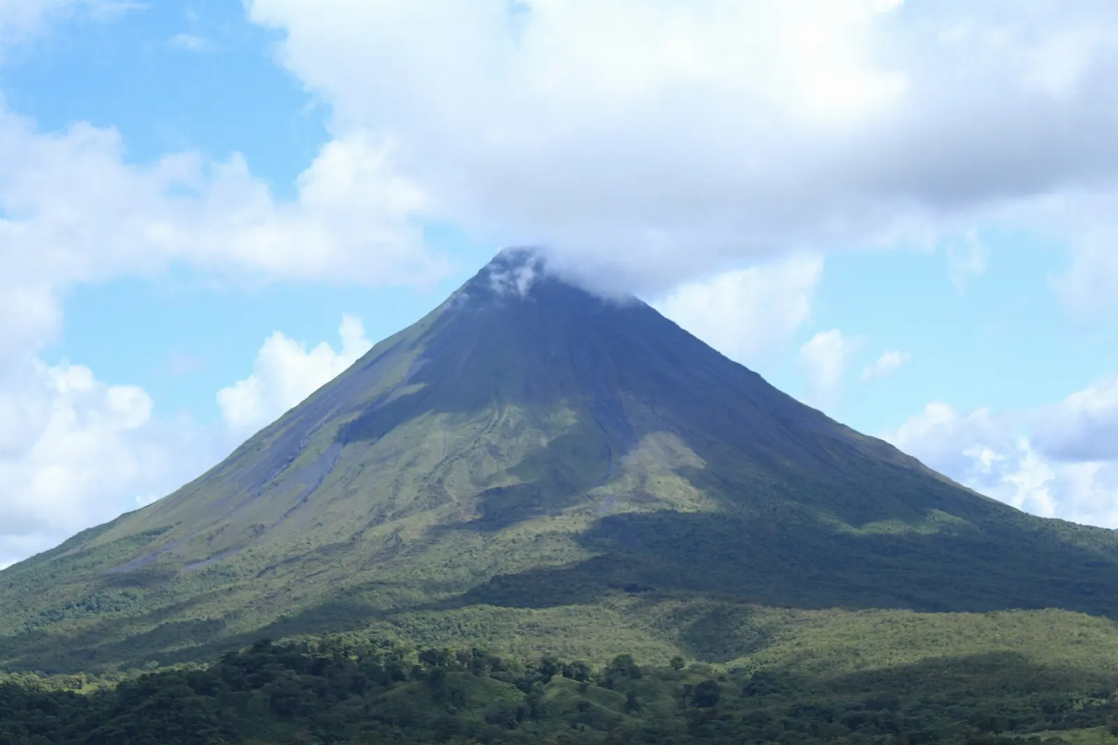 A hiking trail crossing an old lava flow overgrown with shrubs below Arenal Volcano, Costa Rica