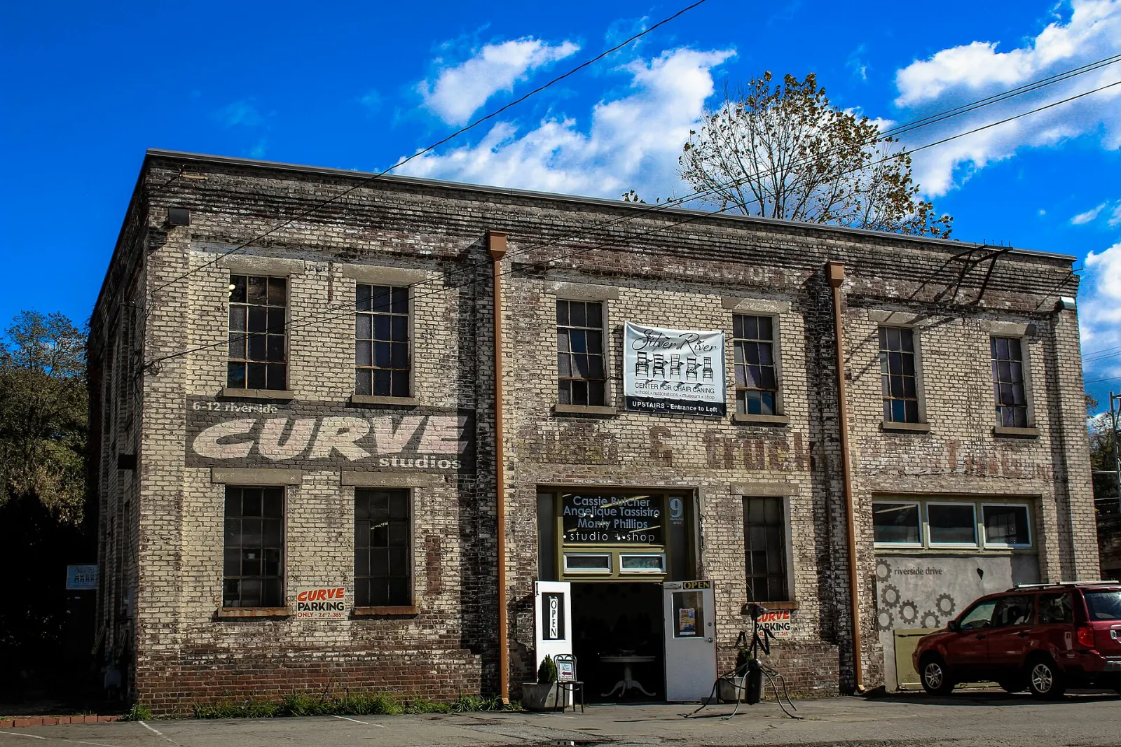Brick warehouses covered in murals along a riverside street, Asheville, North Carolina