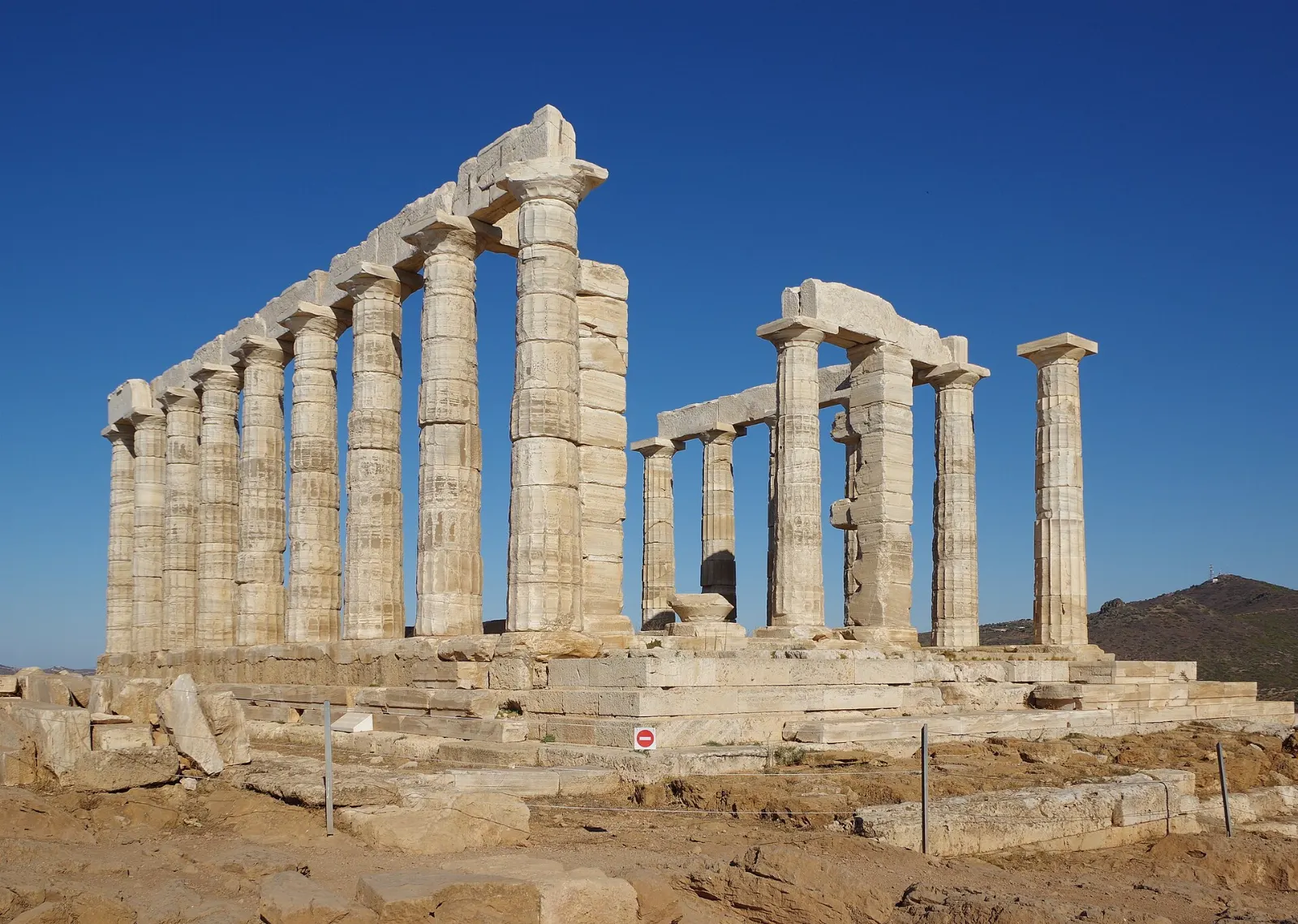 Marble columns of the Temple of Poseidon on a headland above the sea at sunset, Athens, Greece