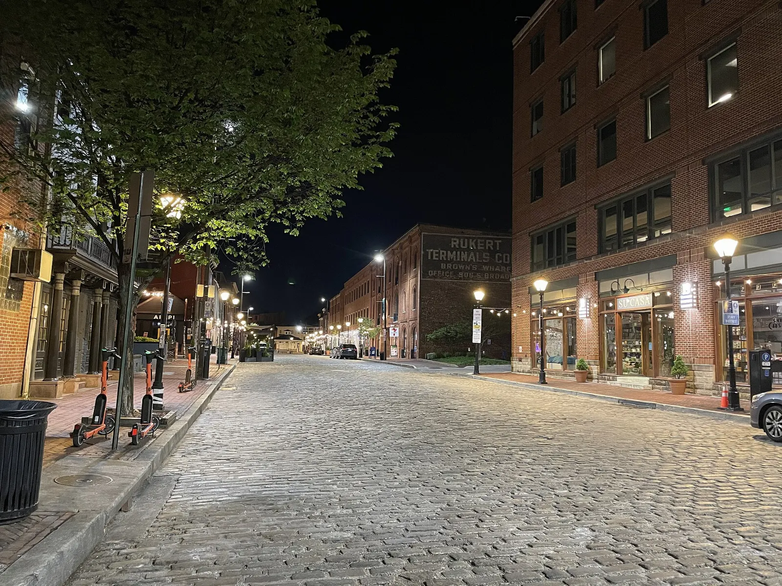 Cobblestone Thames Street lined with brick rowhouses and pubs in Fells Point, Baltimore, Maryland
