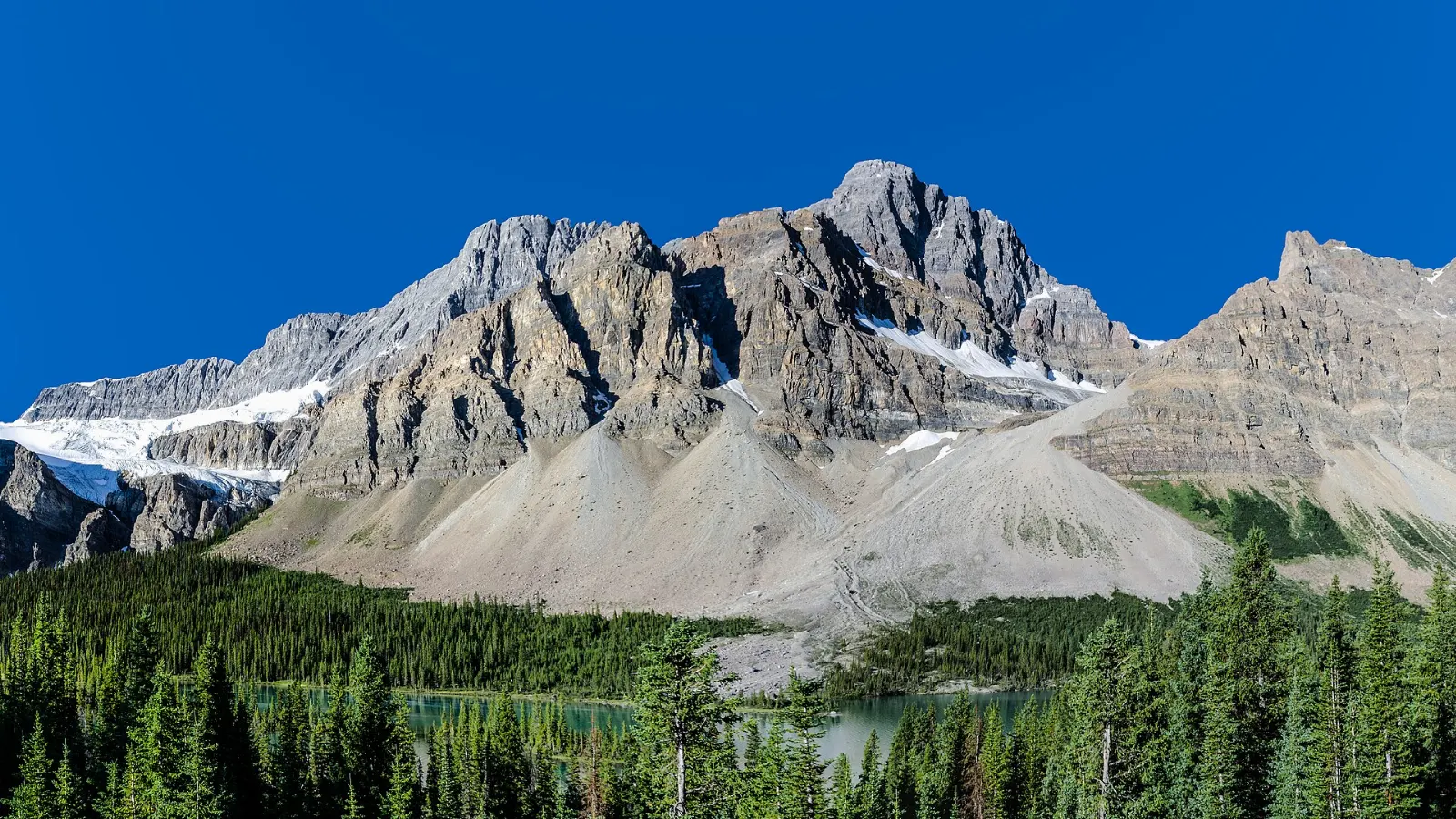 Bow Lake with Crowfoot Mountain and glaciers reflected in still water, Banff National Park, Canada