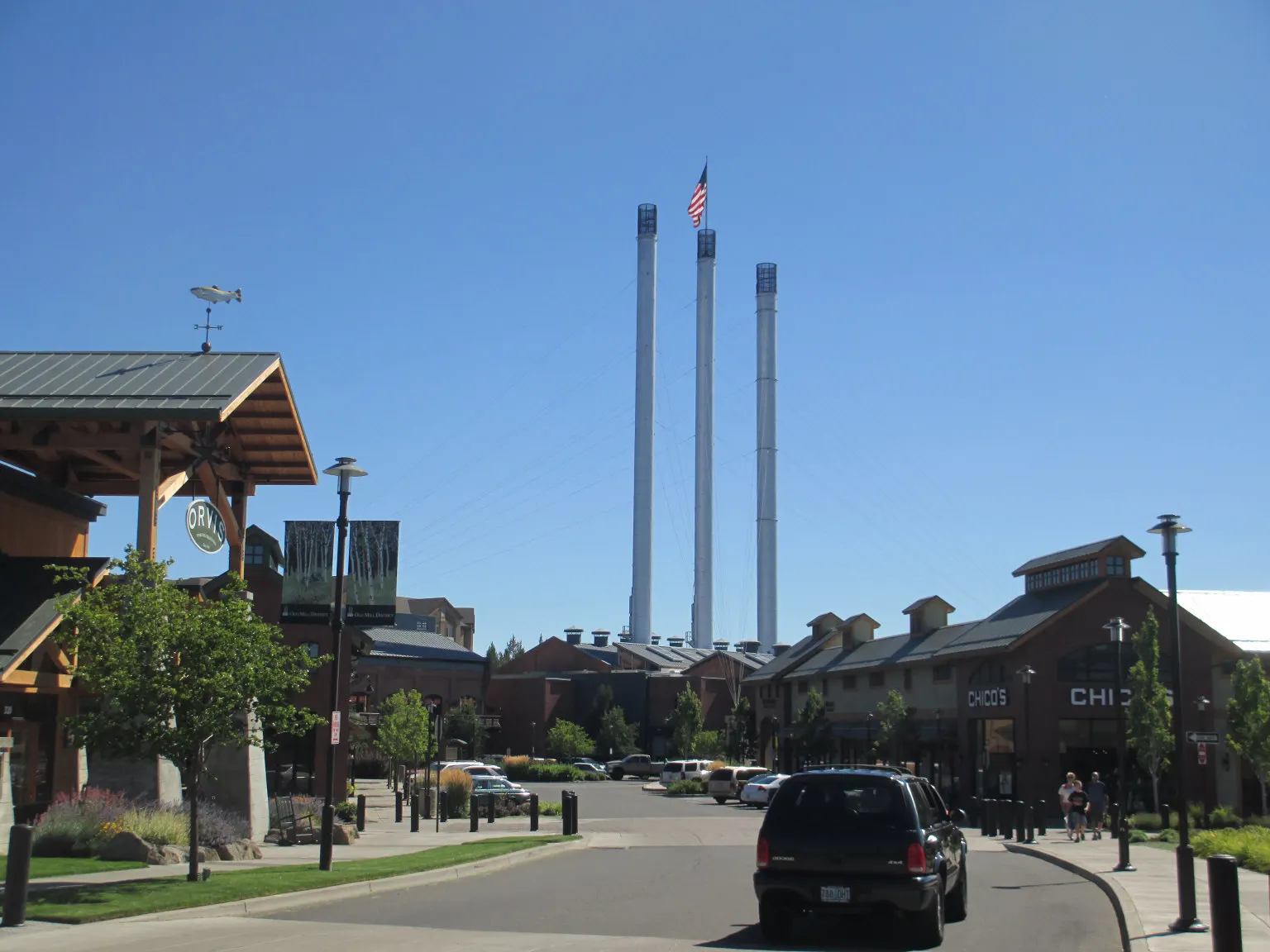 The three tall smokestacks of the former mill building in Bend's Old Mill District beside the river, Oregon