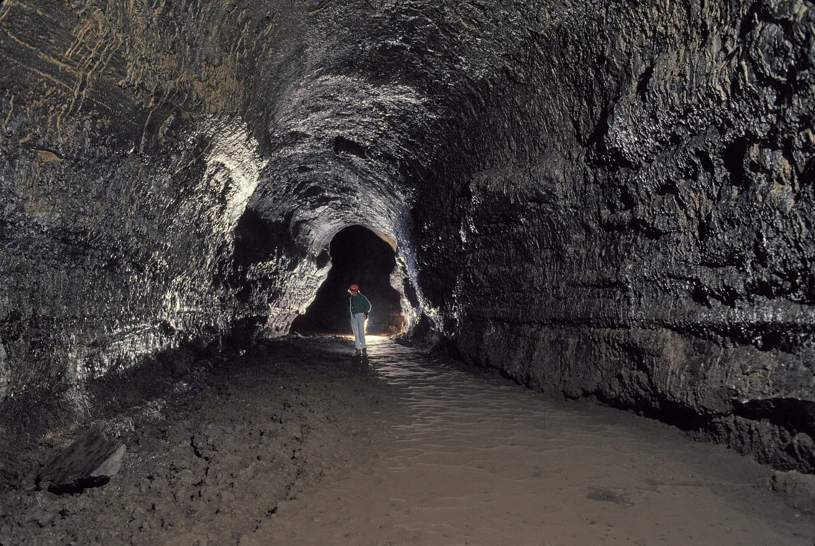 Inside the Lava River Cave, a long dark lava tube with a rounded ceiling, Bend, Oregon