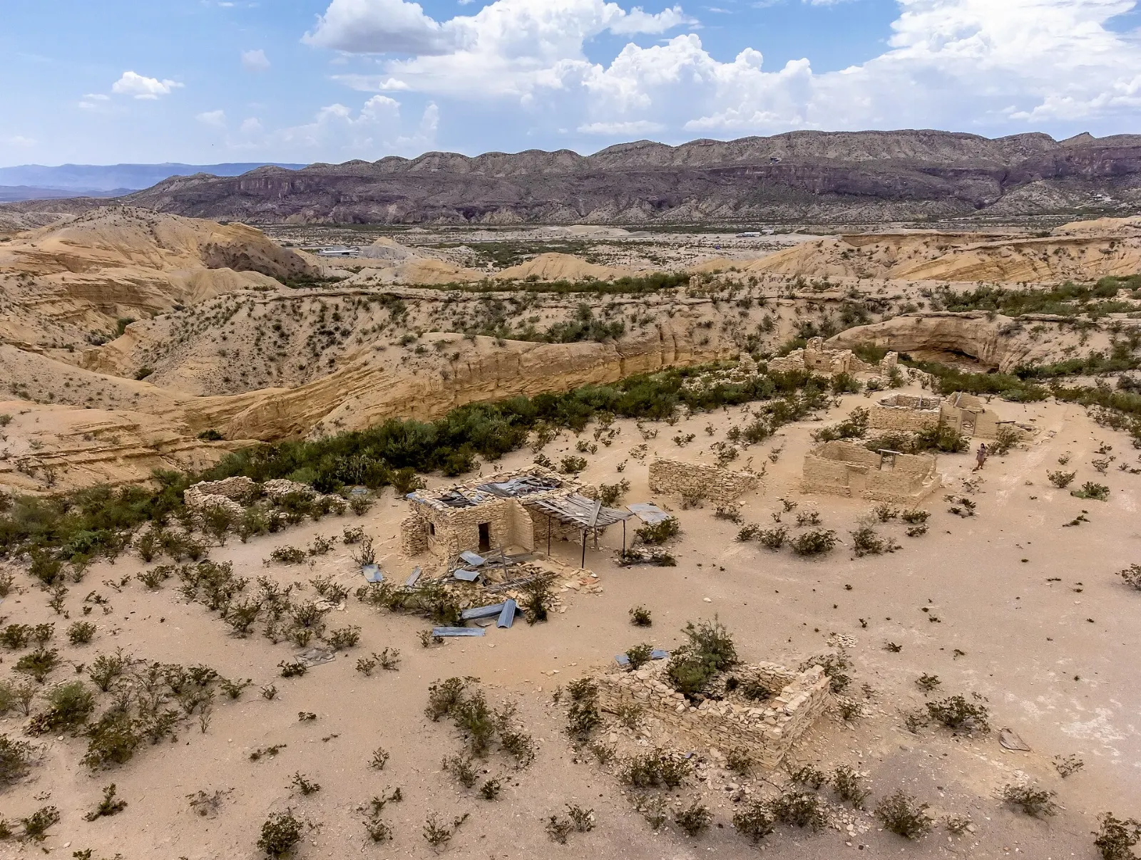 Stone ruins of mining-era buildings in Terlingua ghost town with mountains behind, Big Bend National Park, Texas