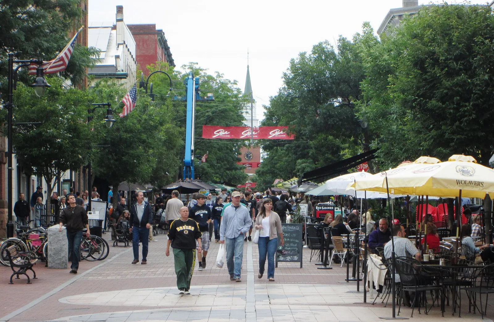 Brick-paved pedestrian Church Street lined with shops, trees and outdoor cafe seating, Burlington, Vermont