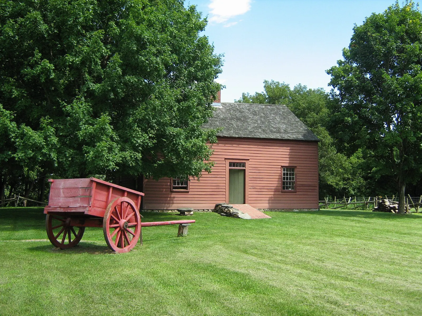 A restored wooden farmhouse at the Ethan Allen Homestead set among fields, Burlington, Vermont
