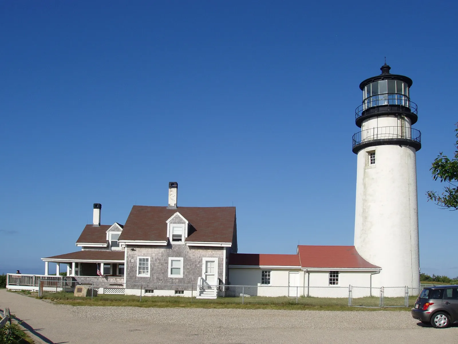 The white Highland Light tower and keeper's house on a grassy bluff in Truro, Cape Cod, Massachusetts