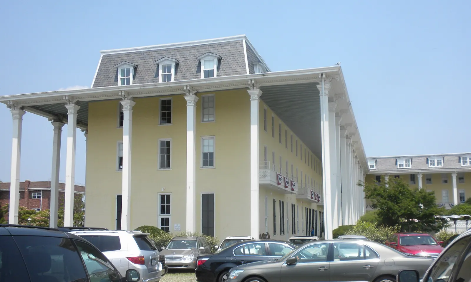 The long yellow facade and columned veranda of Congress Hall facing the ocean, Cape May, New Jersey