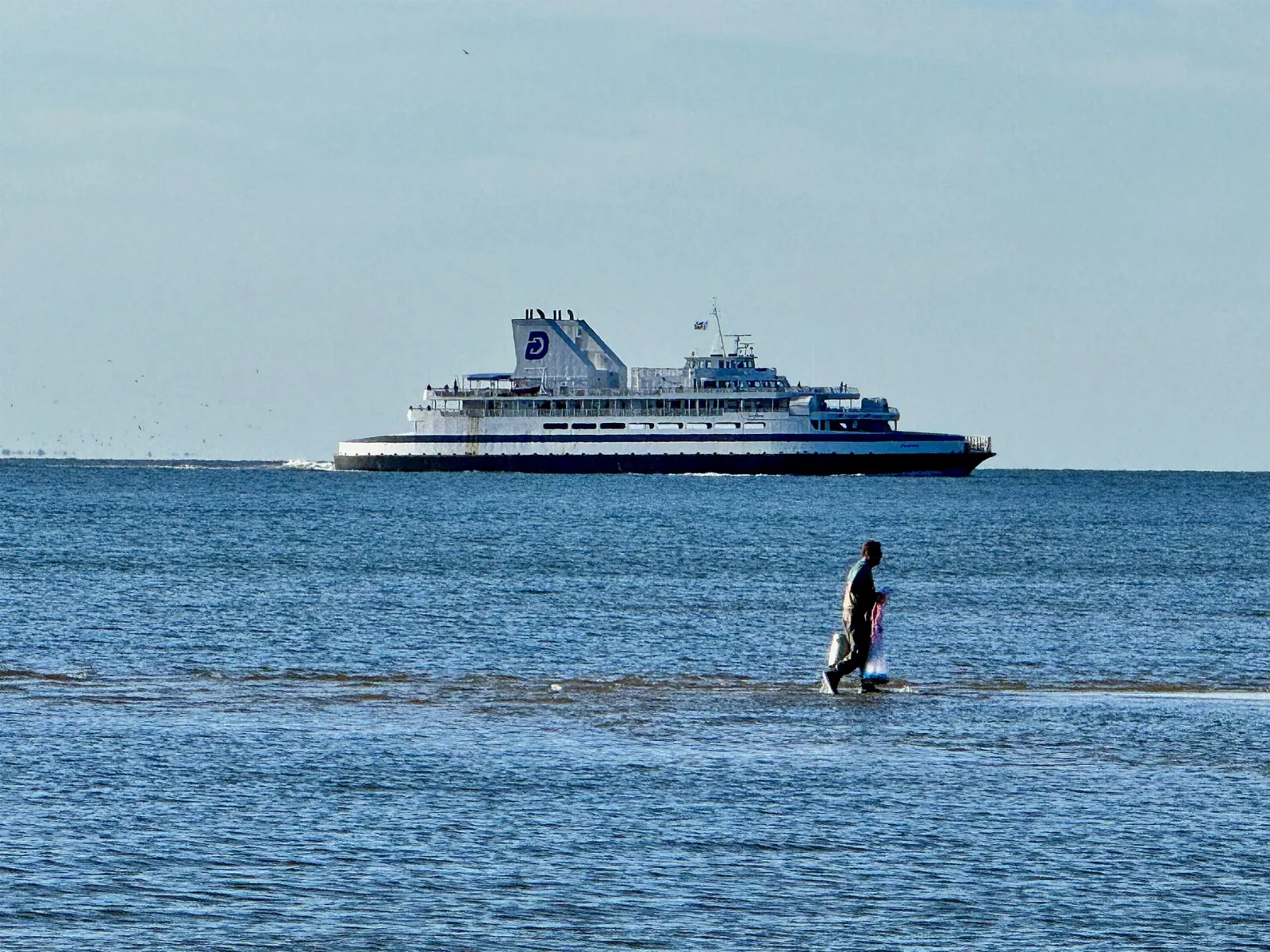 A white car ferry crossing the blue waters of the Delaware Bay, Cape May, New Jersey