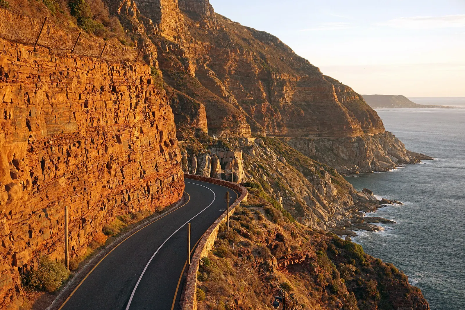 A coastal road carved into cliffs above Hout Bay, Cape Town, South Africa