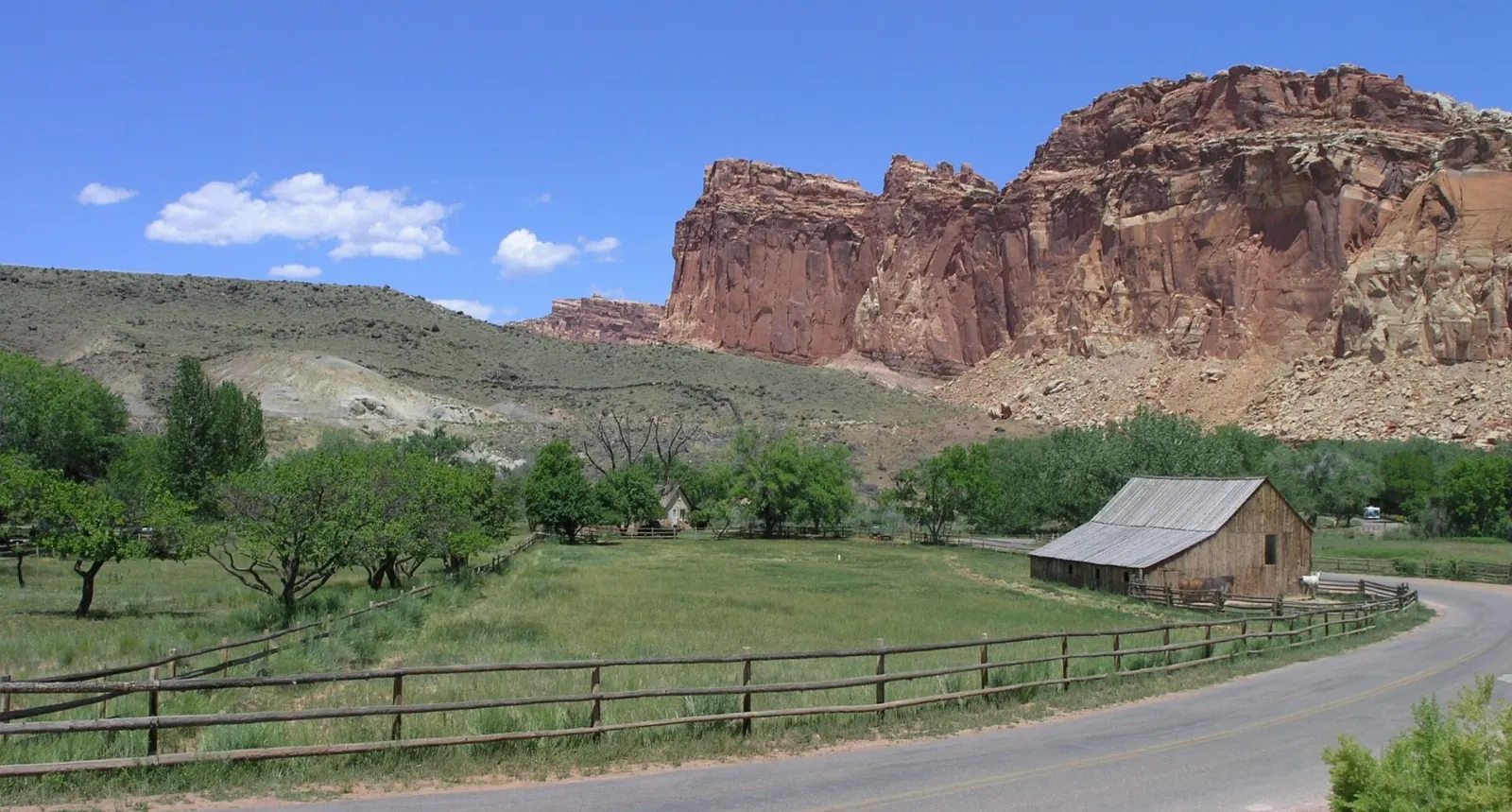 The historic Gifford farmhouse with a white fence and cliffs behind it, Capitol Reef National Park, Utah