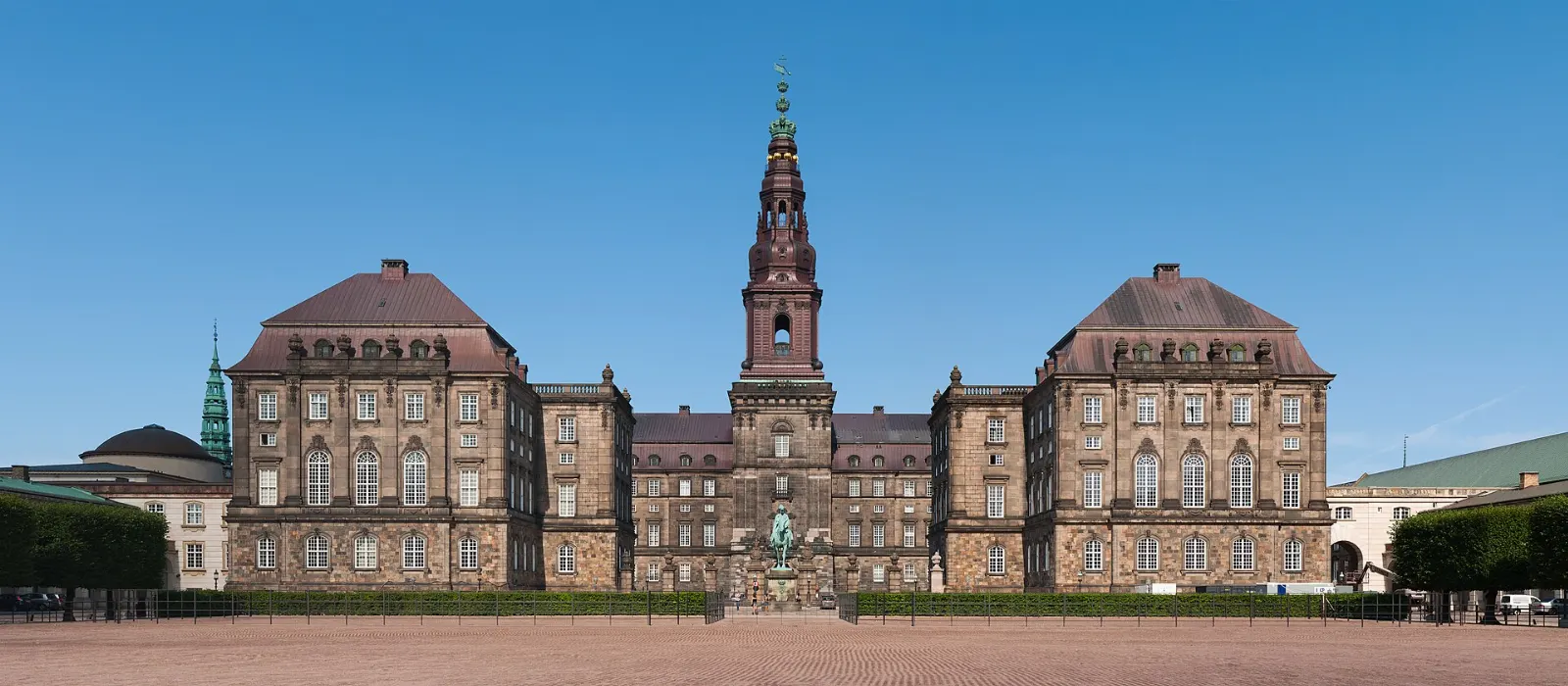 A large palace with a tall green copper tower on an island in the city center, Copenhagen, Denmark