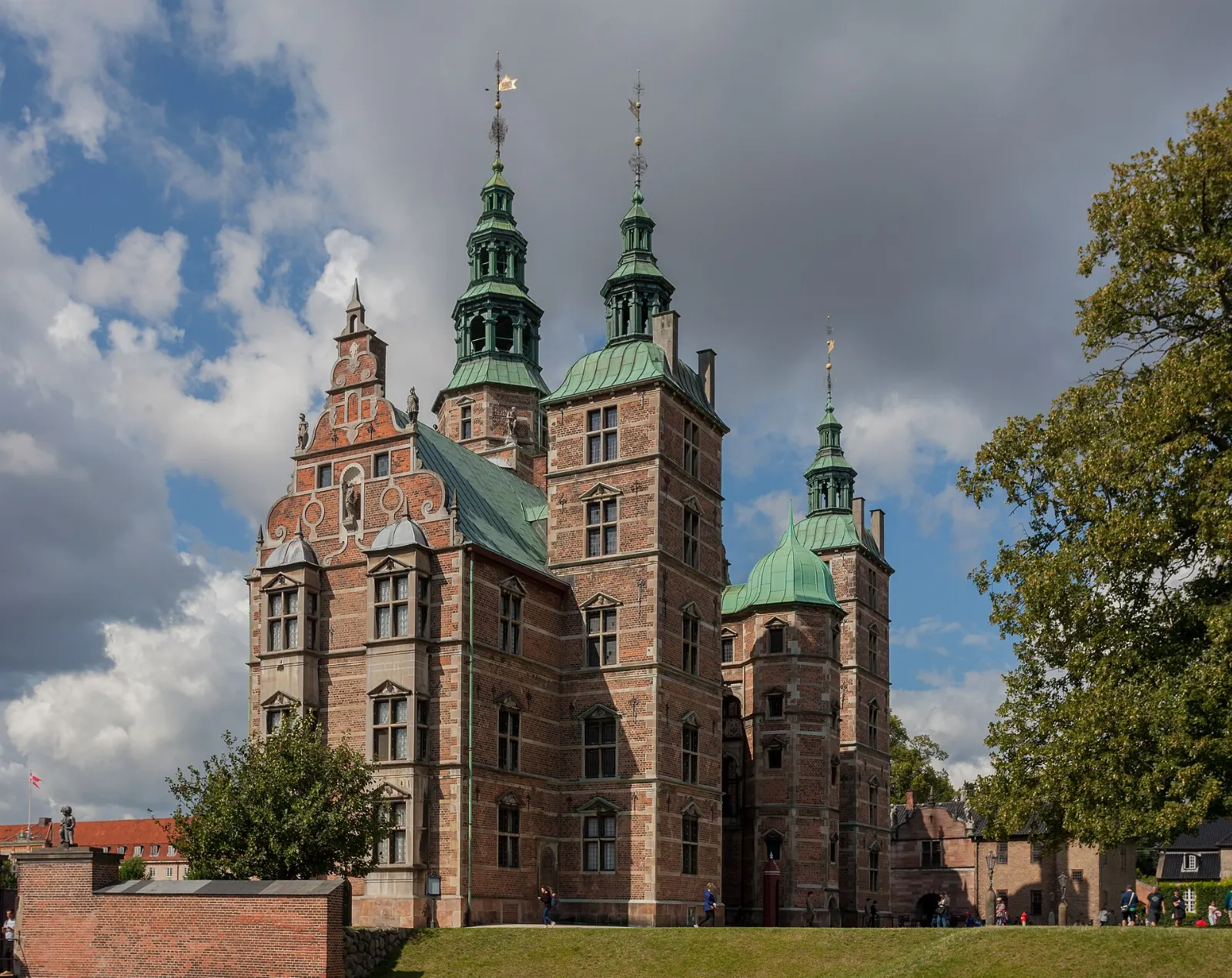 A red brick Renaissance castle with spires and towers beside a garden, Copenhagen, Denmark