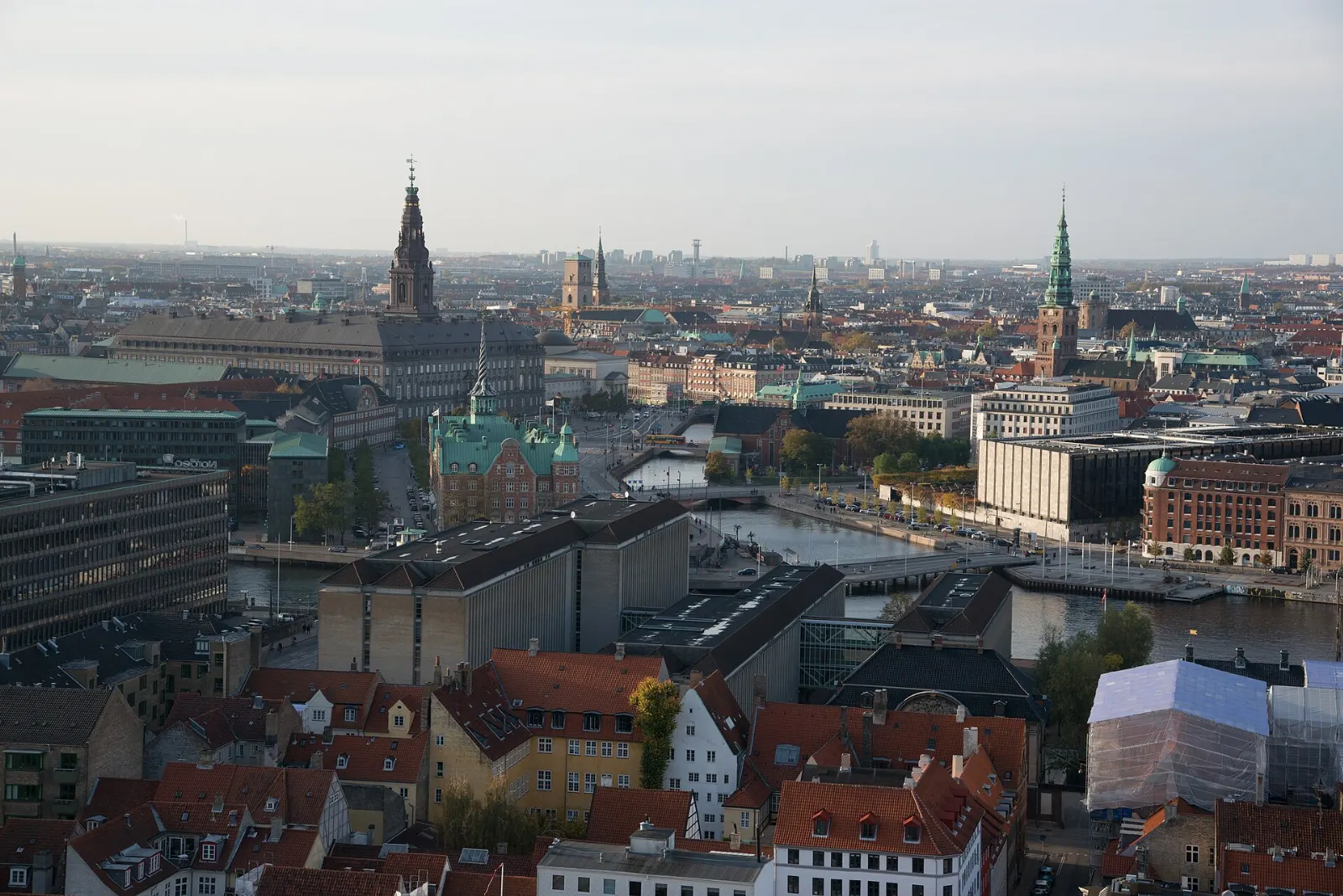 A dark church spire wrapped by an external golden spiral staircase, Copenhagen, Denmark