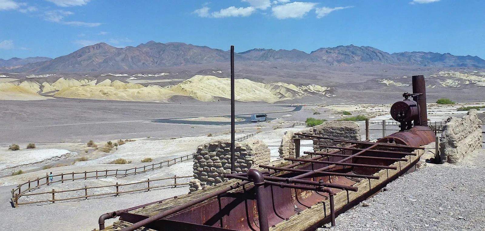 Ruins of an adobe borax refinery beside historic wagons on the desert floor, Death Valley National Park, California