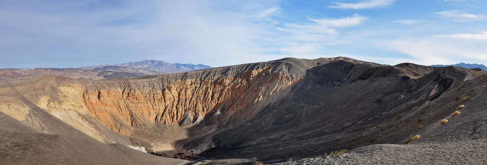 A huge volcanic crater with striped walls of orange and black rock, Death Valley National Park, California