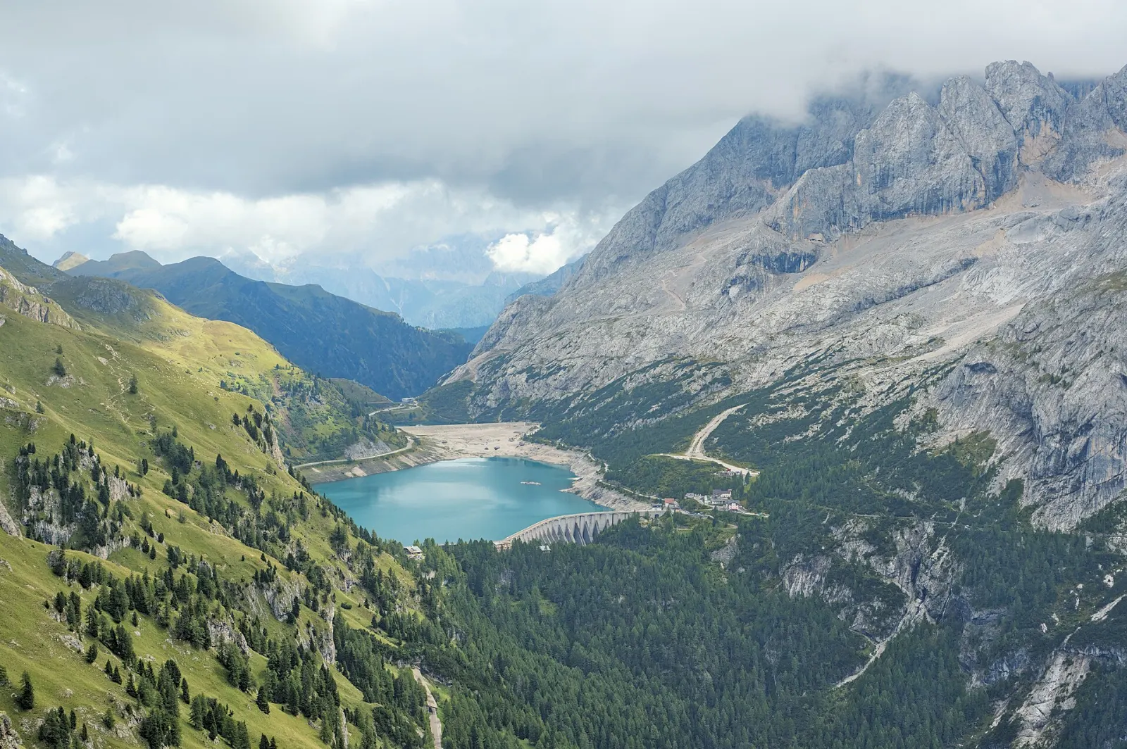 A glacier-topped mountain above a turquoise reservoir, Dolomites, Italy