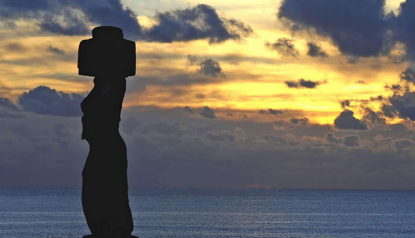 A single moai with restored eyes and a red topknot at Tahai near Hanga Roa, Easter Island, Chile