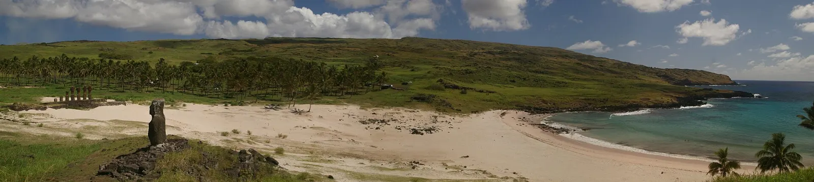 Moai of Ahu Nau Nau standing above the white sand and palms of Anakena beach, Easter Island, Chile