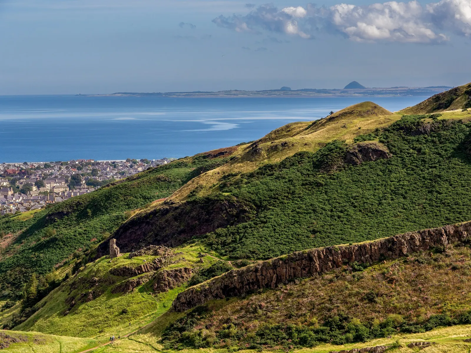 Grassy summit of Arthur's Seat with the city spread below, Edinburgh, Scotland