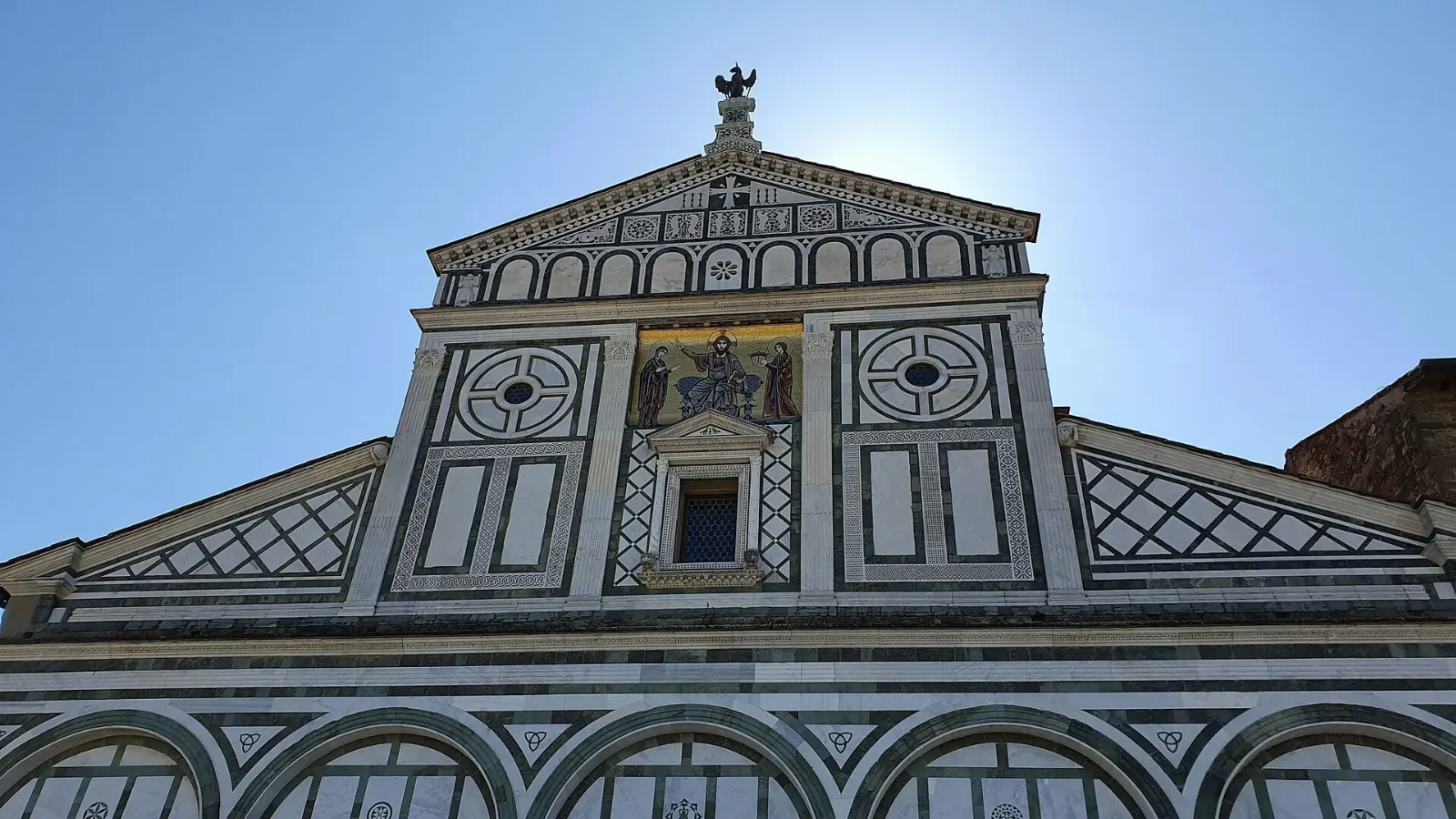 The green and white marble Romanesque facade of San Miniato al Monte on its hilltop, Florence, Italy