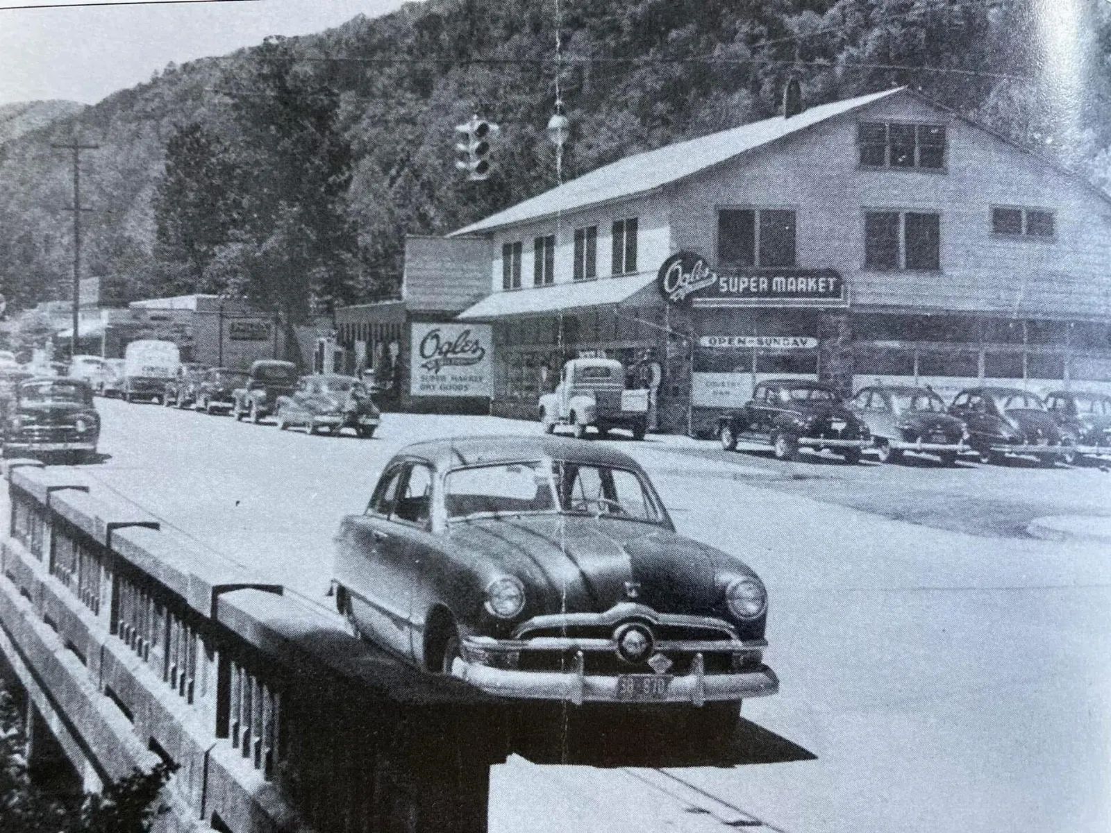 Shops and restaurants along the Parkway in downtown Gatlinburg with forested mountains behind, Tennessee