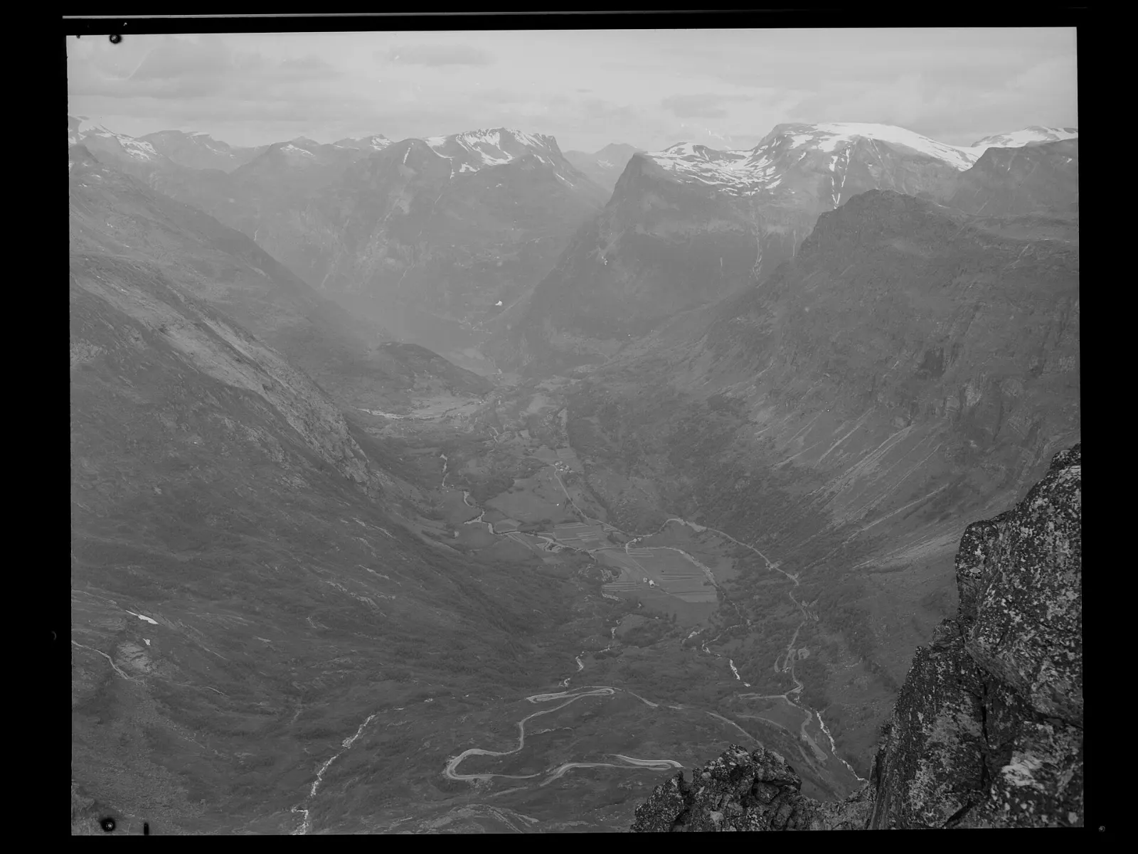 View from the summit of Dalsnibba over snowy mountains and the valley toward Geirangerfjord, Norway