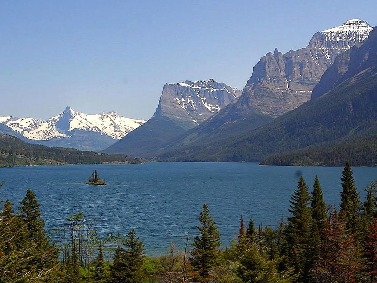 A tiny tree-covered island in St. Mary Lake with mountains rising beyond, Glacier National Park, Montana