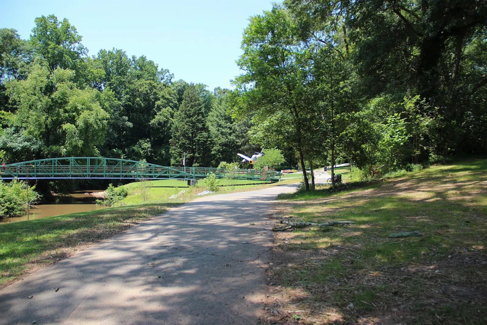 Paved greenway trail with cyclists following the Reedy River, Greenville, South Carolina