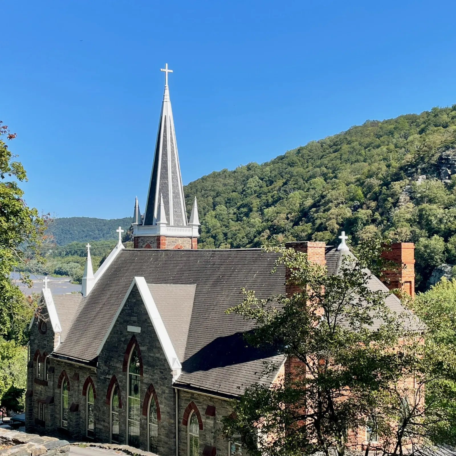 Gothic stone church with a tall spire on the hillside above Lower Town, Harpers Ferry, West Virginia