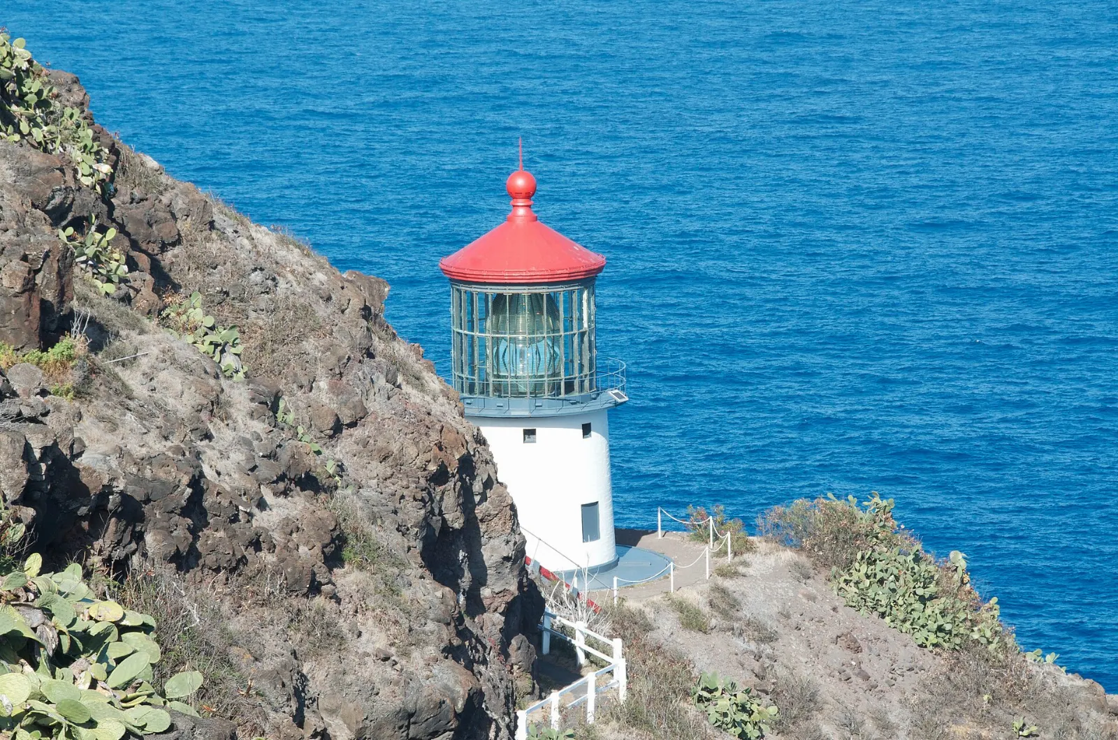 Red-roofed Makapuu Point Lighthouse above turquoise water and offshore islets, Honolulu, Hawaii
