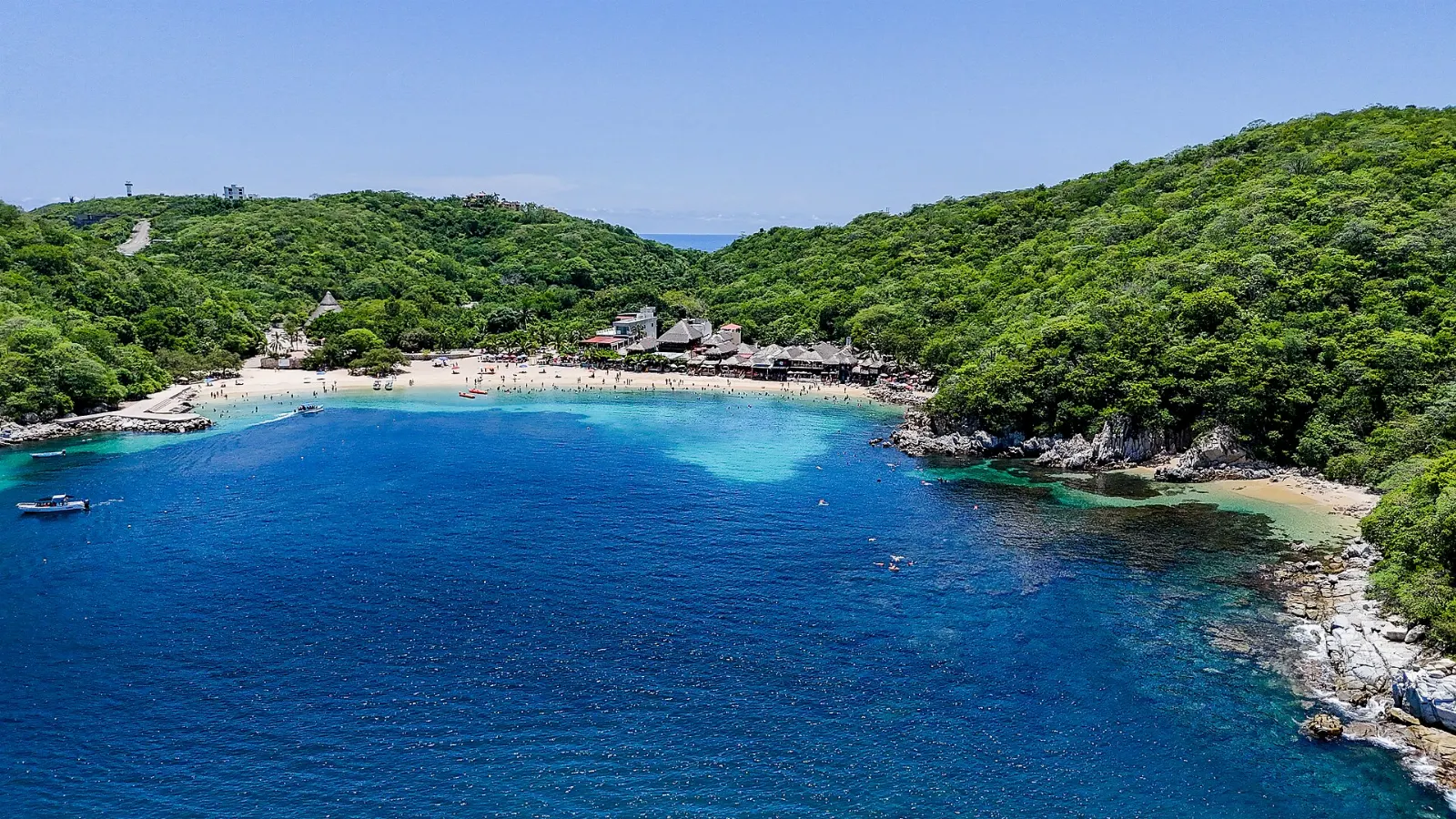 Calm water and beach palapas at Playa La Entrega, Huatulco, Oaxaca