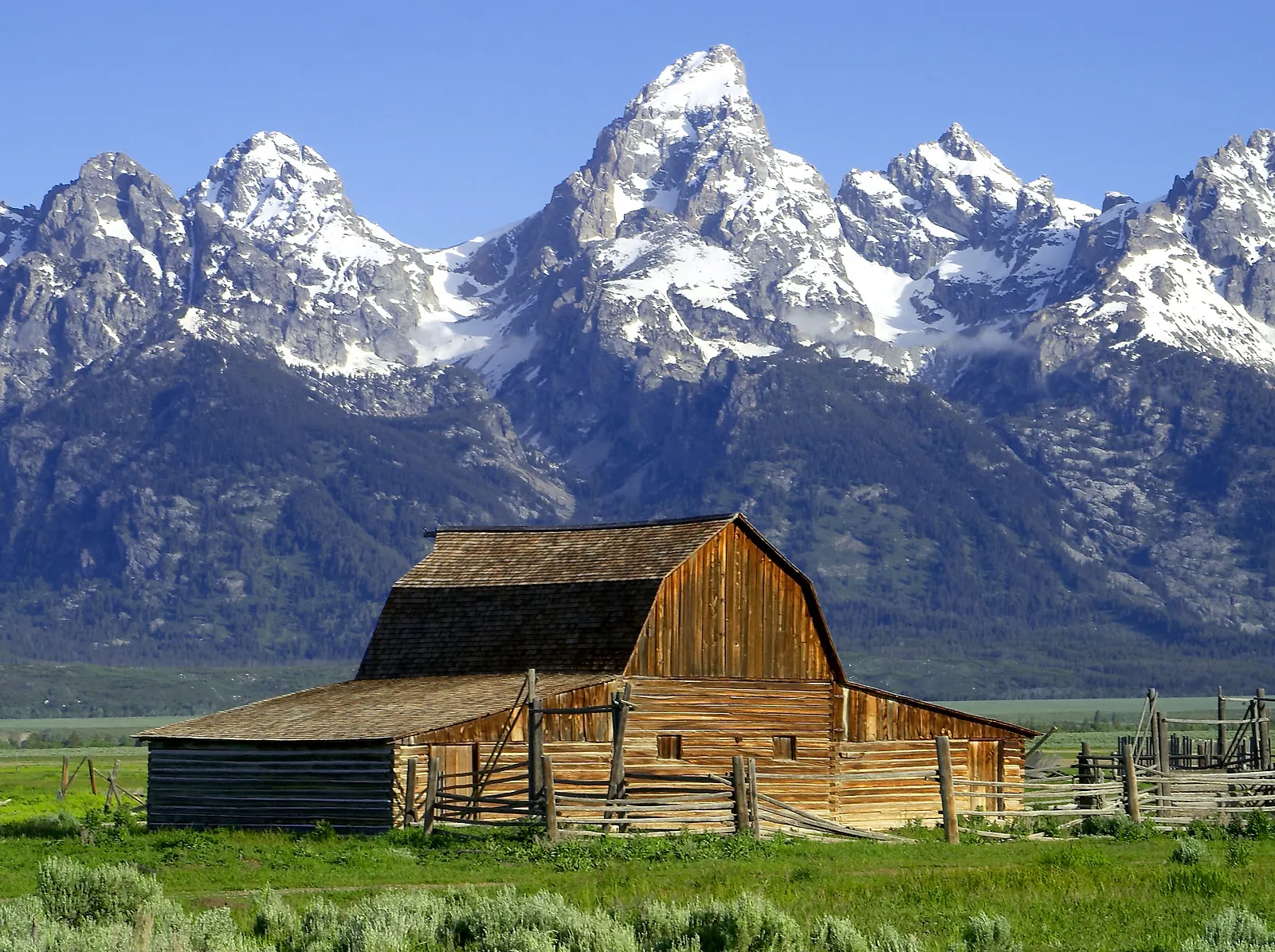 A weathered wooden barn with the Teton Range behind it on Mormon Row, Jackson Hole, Wyoming