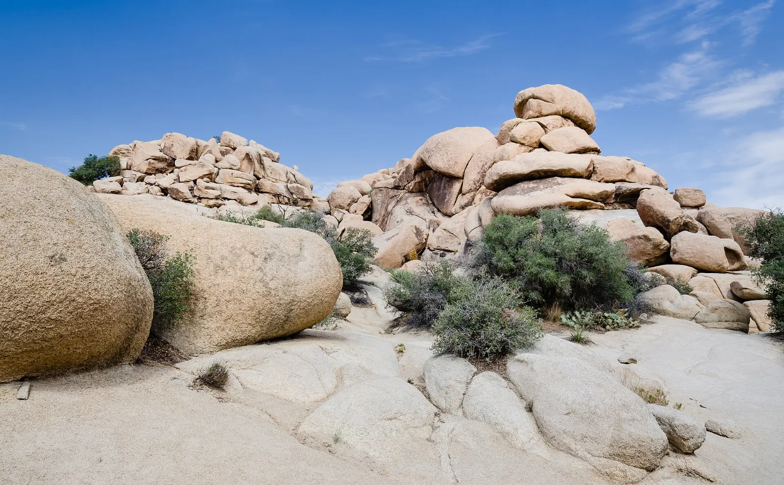 A small reservoir reflecting granite boulders behind a historic concrete dam, Joshua Tree National Park, California