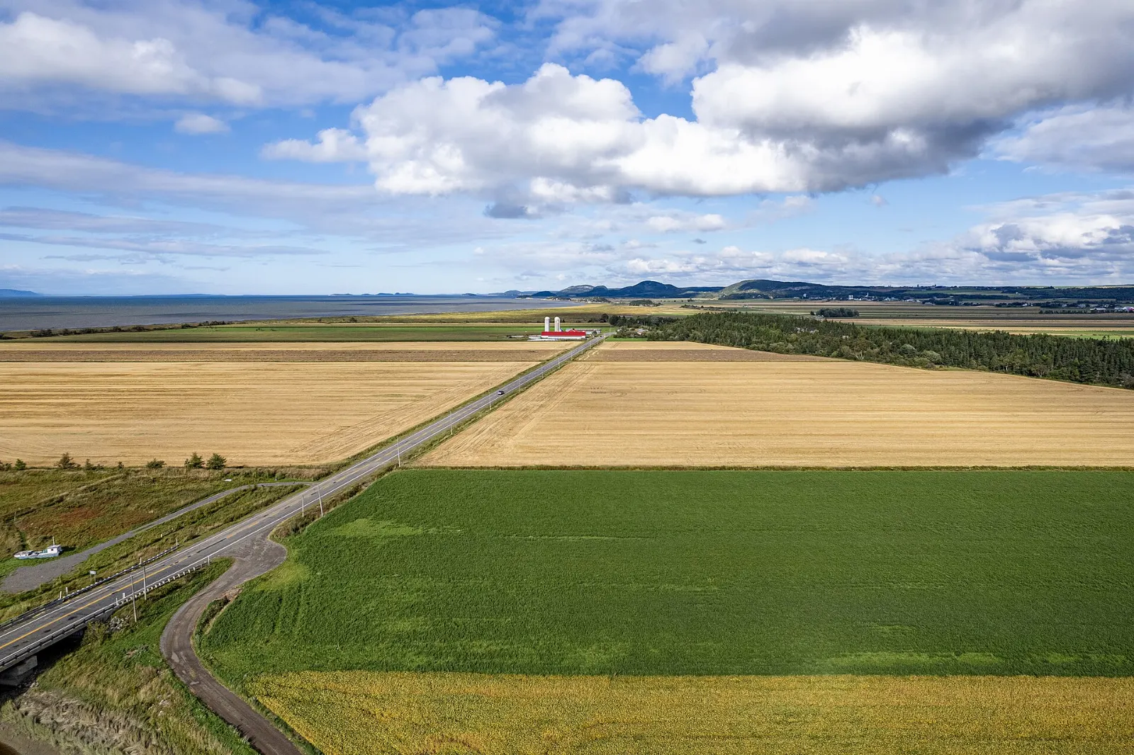 Road running along farmland near the St. Lawrence River in Bas-Saint-Laurent, Kamouraska, Quebec
