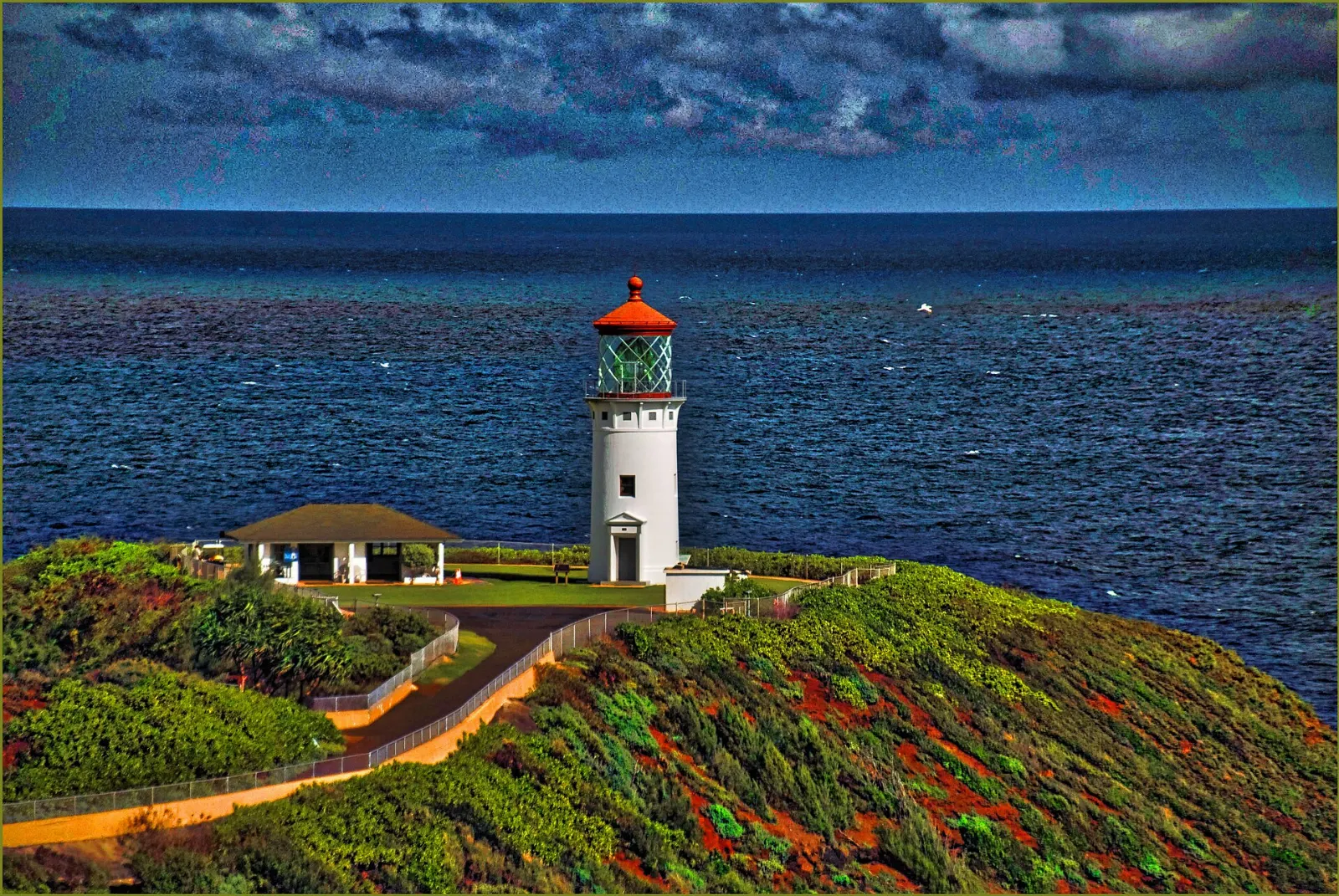 White Kilauea Lighthouse with a red top on a narrow point above the sea, Kauai, Hawaii