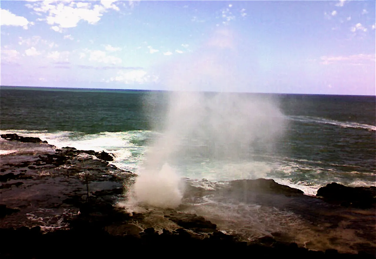 Spray of seawater bursting from a lava tube on the rocky Poipu coast, Kauai, Hawaii