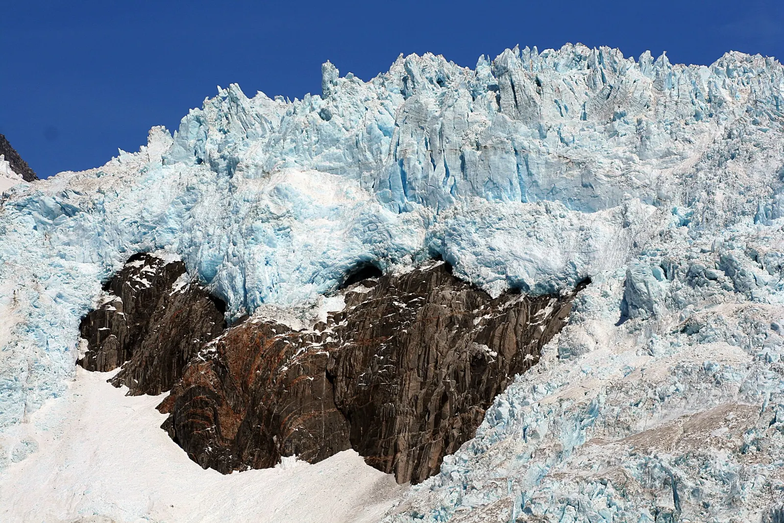 A remote fjord with glaciers spilling from mountains into icy water, Kenai Fjords National Park, Alaska