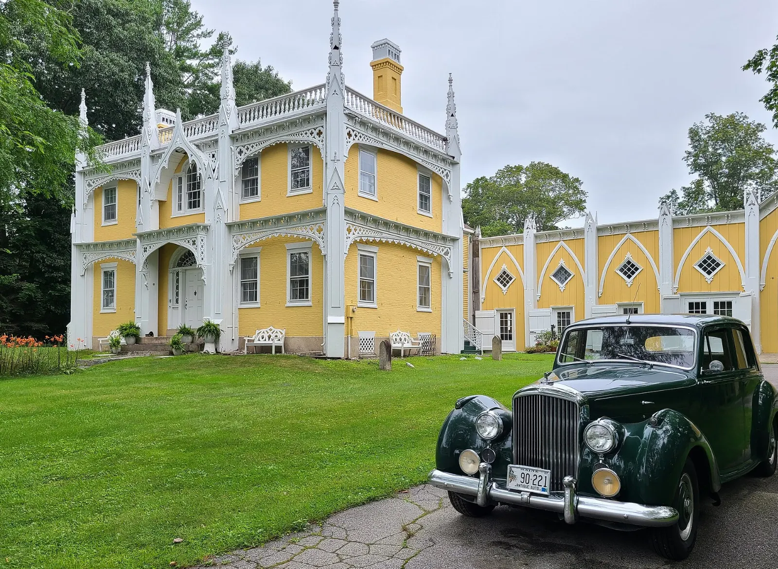 Yellow Federal-style house covered in white Gothic wooden trim in Kennebunk, Kennebunkport, Maine