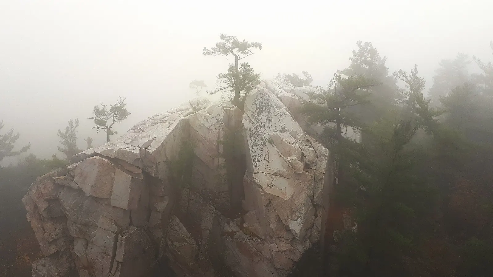Hikers climbing through a rocky chasm at The Crack, Killarney Provincial Park, Ontario