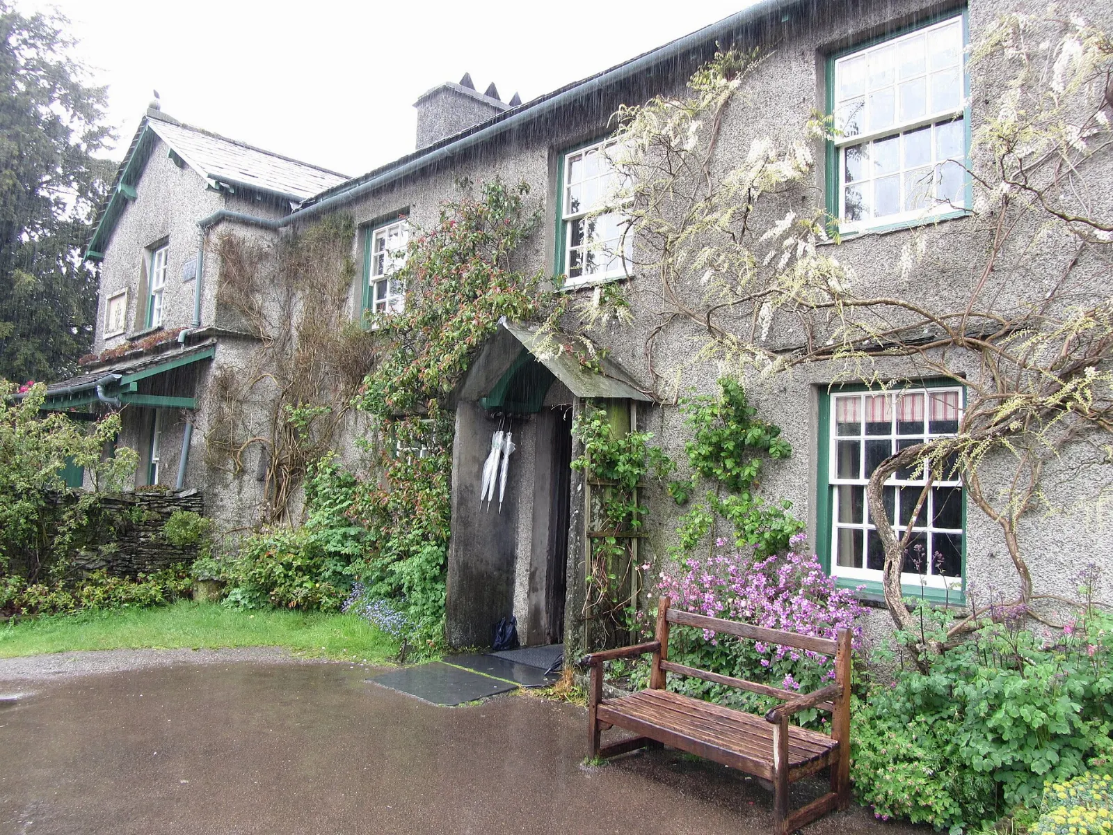 A slate-roofed stone farmhouse with a cottage garden at Hill Top, Lake District, England
