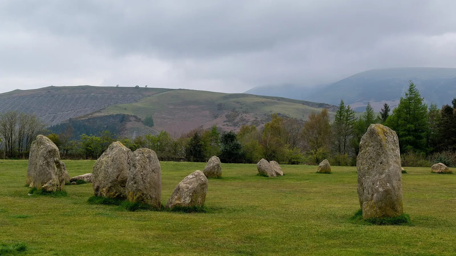 A ring of standing stones on a grassy plateau encircled by fells near Keswick, Lake District, England