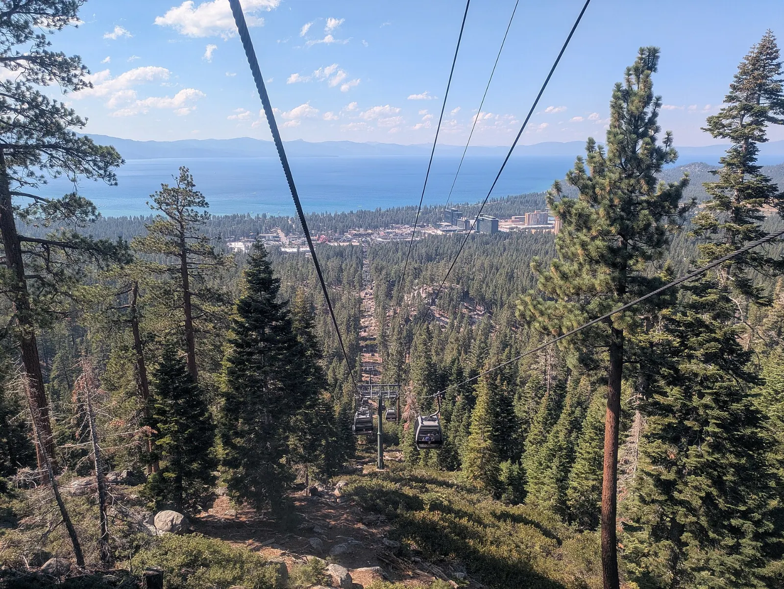 A gondola cabin rising above South Lake Tahoe with the lake below