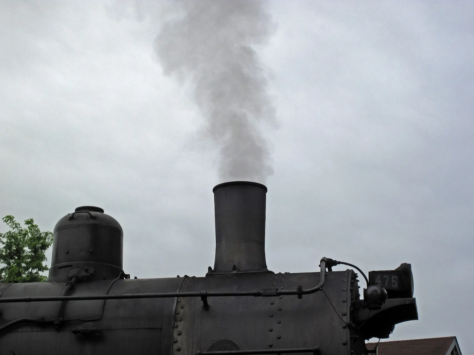 A black steam locomotive pulling vintage passenger coaches through farmland near Strasburg, Lancaster County, Pennsylvania