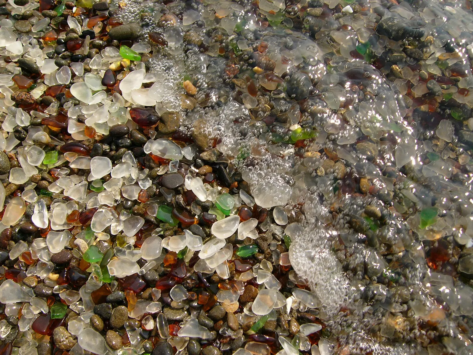 Rounded pieces of colored sea glass among pebbles on Glass Beach, Mendocino, California